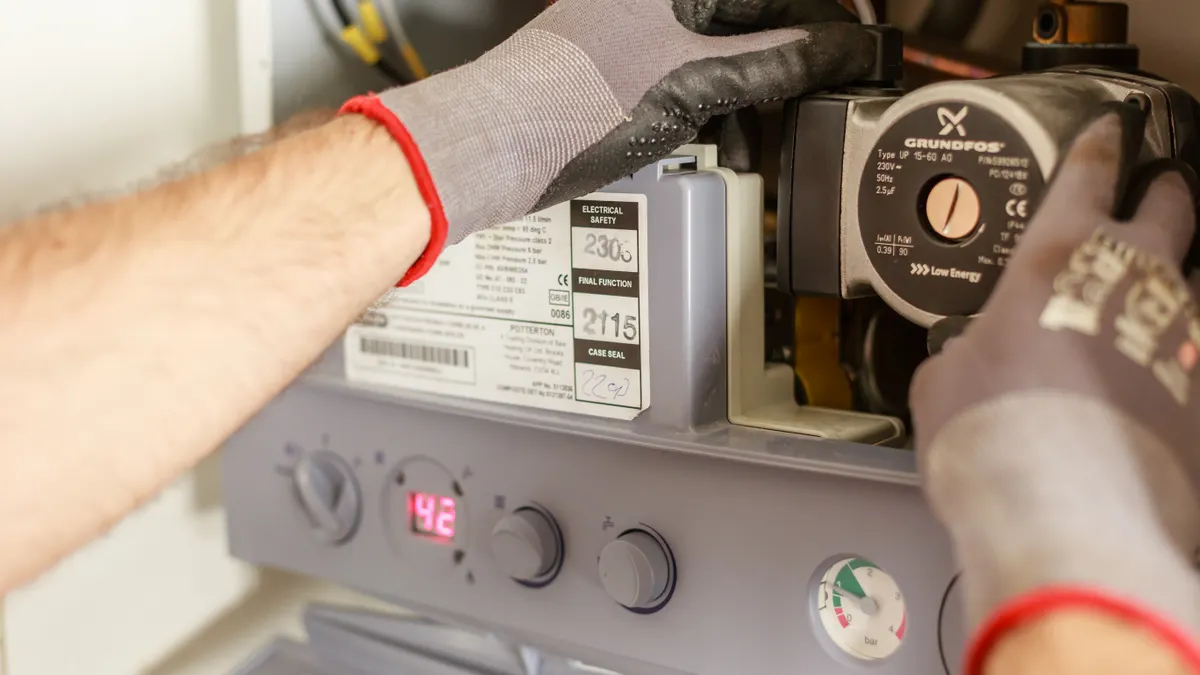 Hands adjusting a water heater or boiler