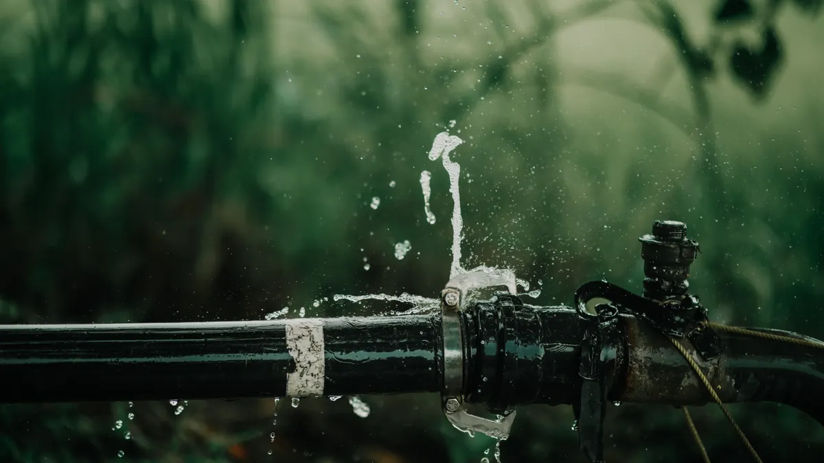 Water spraying from a leaking pipe outdoors