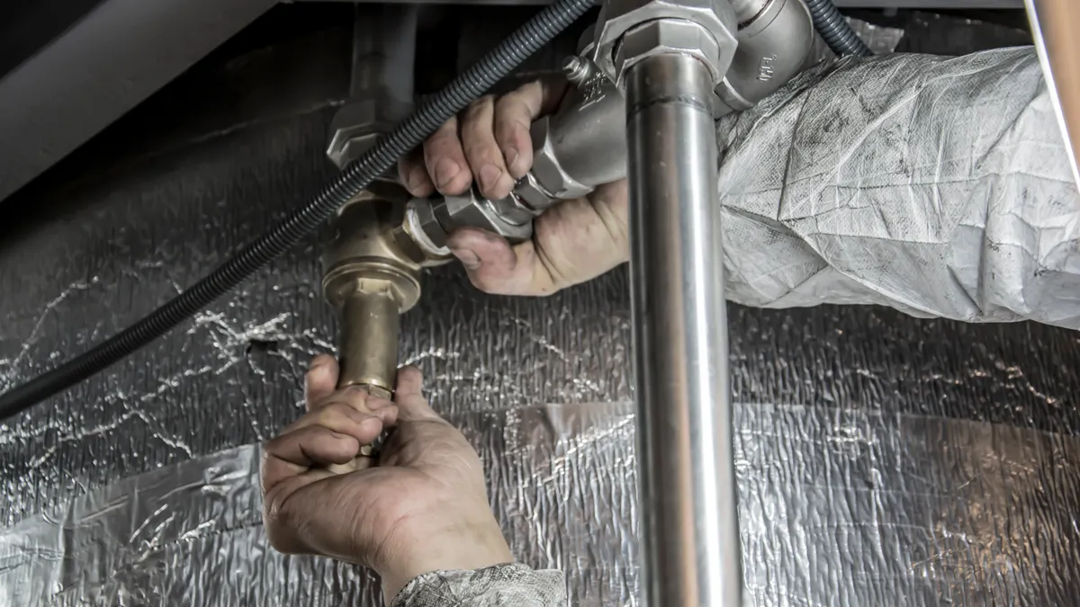 Plumber repairing pipes under a building