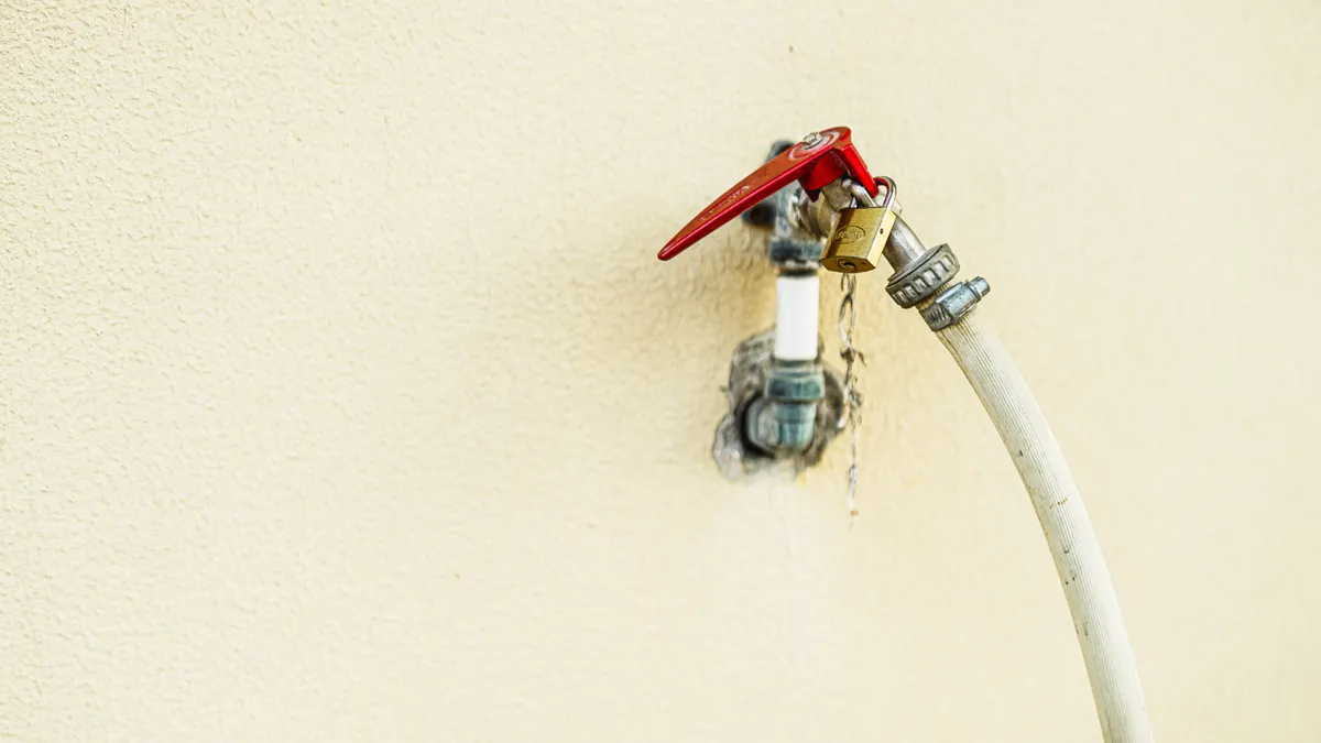 Emergency Plumbing Repairs — The Complete Guide Outdoor wall faucet with hose attached