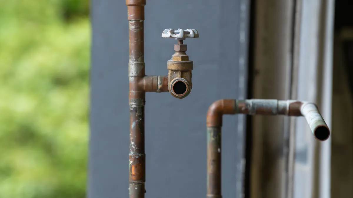 Emergency Plumbing Repairs — The Complete Guide Rusty pipe and shutoff valve by a wall