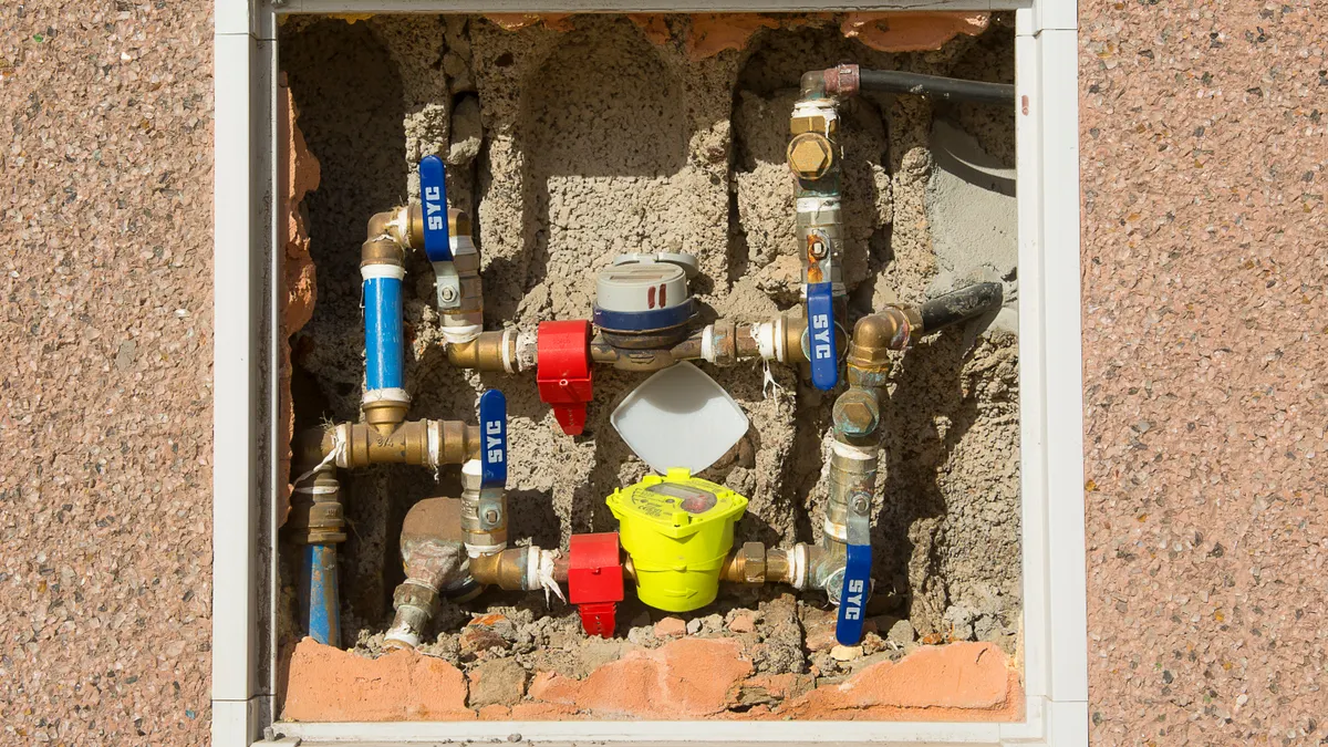 How to Find an Emergency Plumber Fast Exposed plumbing pipes and valves in a wall opening