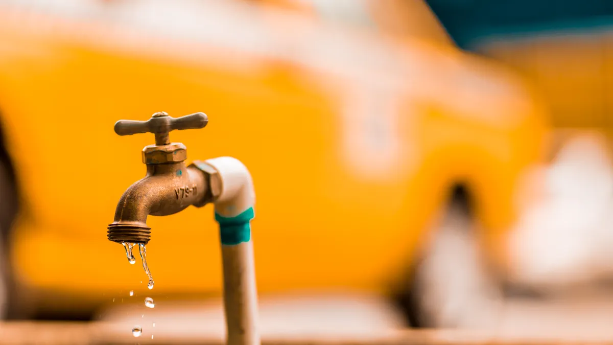 How to Find an Emergency Plumber Fast Leaking outdoor faucet with blurred car behind